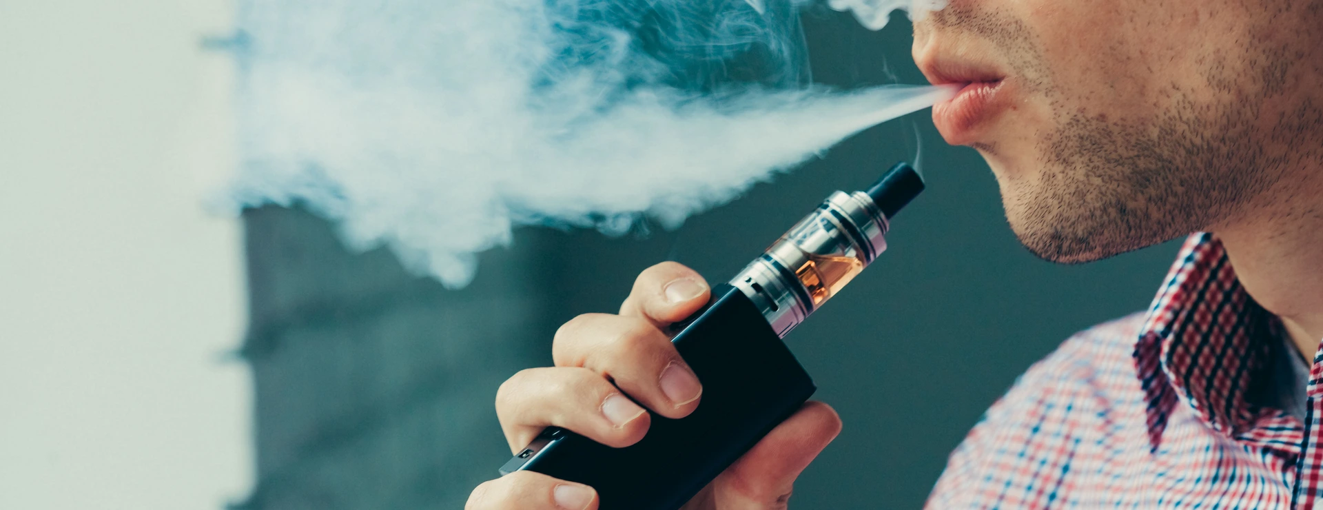 Close up on a man exhaling vapor from an electronic cigarette