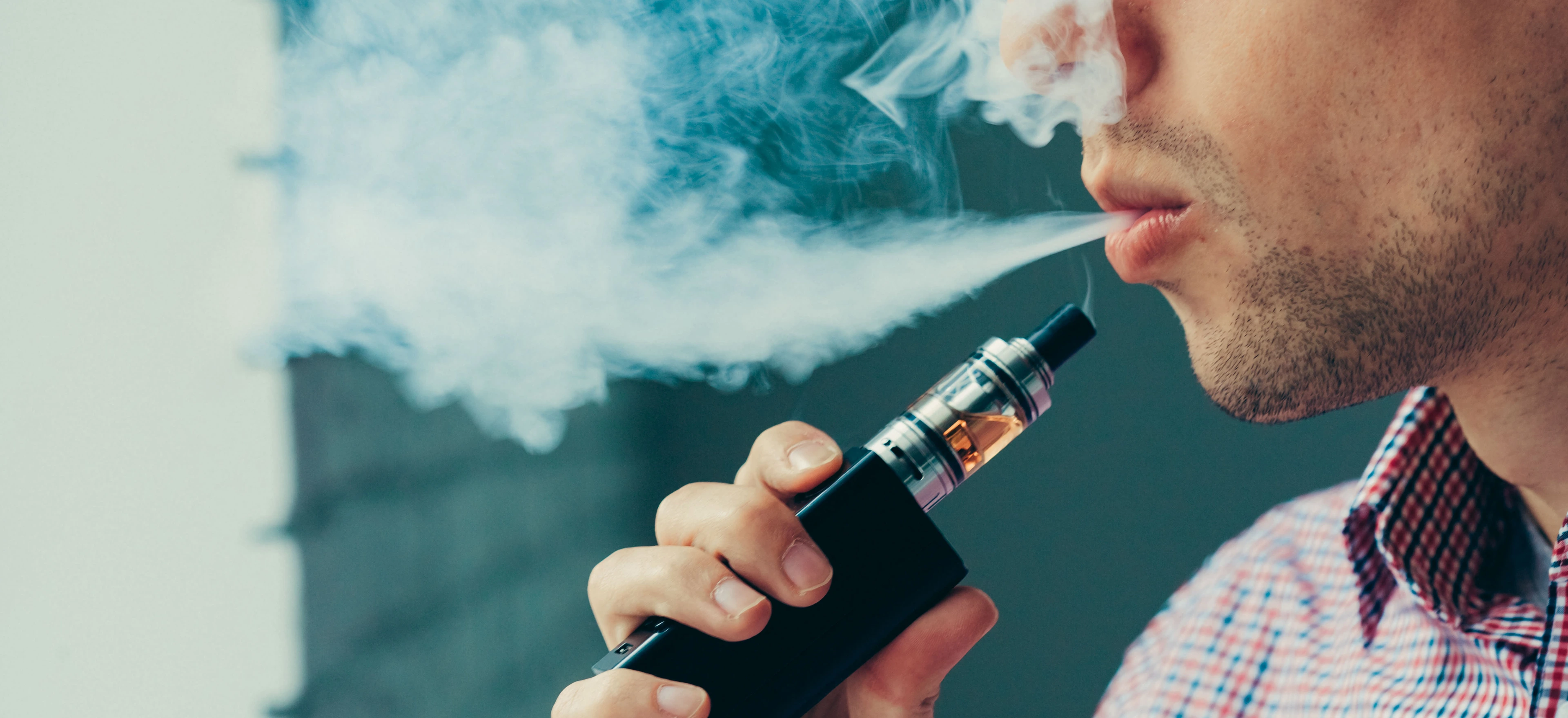 Close up on a man exhaling vapor from an electronic cigarette
