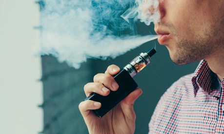 Close up on a man exhaling vapor from an electronic cigarette