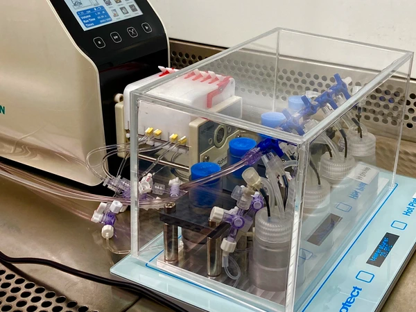 Kasten mit Flaschen, die mit Schläuchen miteinander verbundnen sind