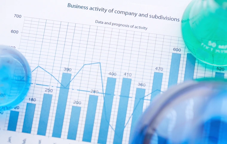 Test-tubes with liquids on paper with business analysis