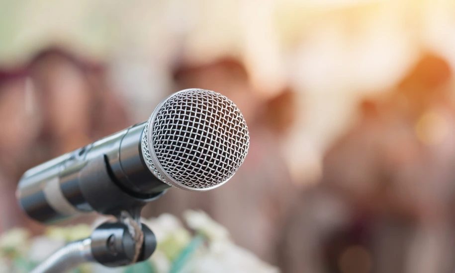 Microphones on abstract blurred of speech in seminar room, speaking conference hall light for presentation in exhibition event Background. Mic is transducer that convert sound into electrical signal.