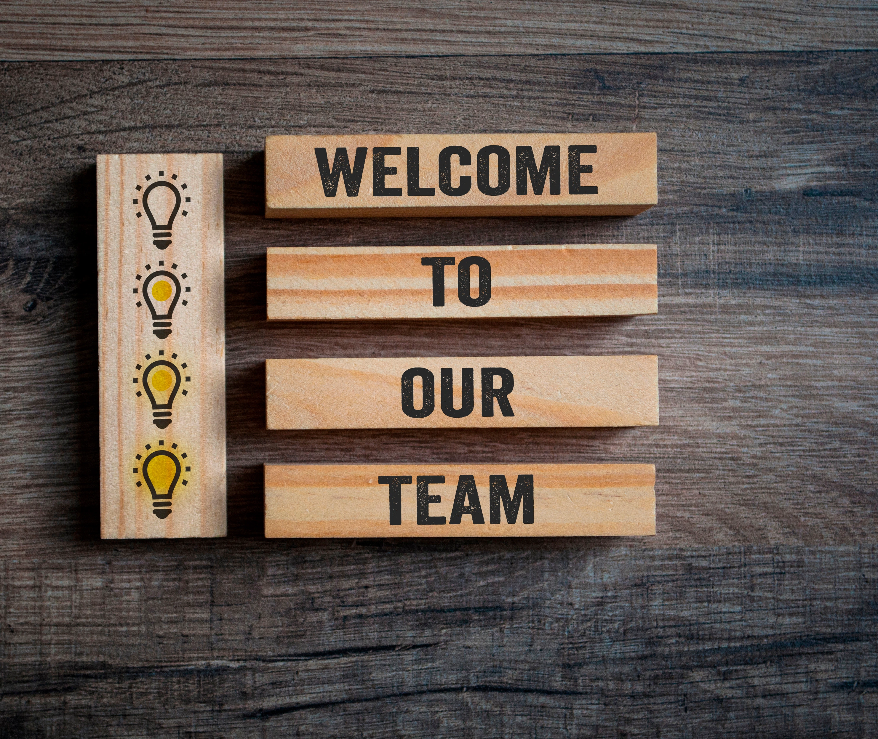 Wooden pieces with light bulbs and message Welcome to our team