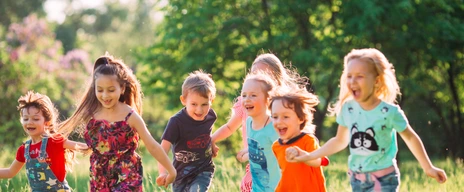 Kinder laufen über eine Wiese