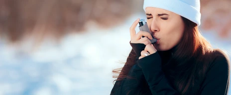 Frau inhaliert im Winter mit Asthmaspray