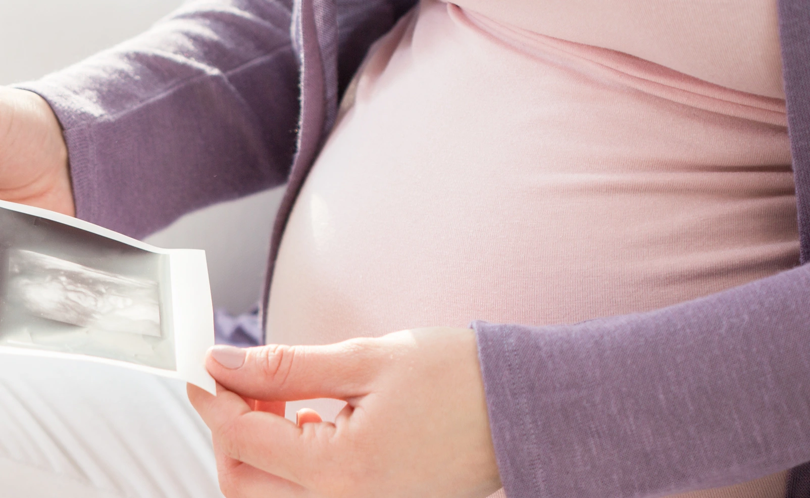 Schwangere Frau mit Ultraschallbildern