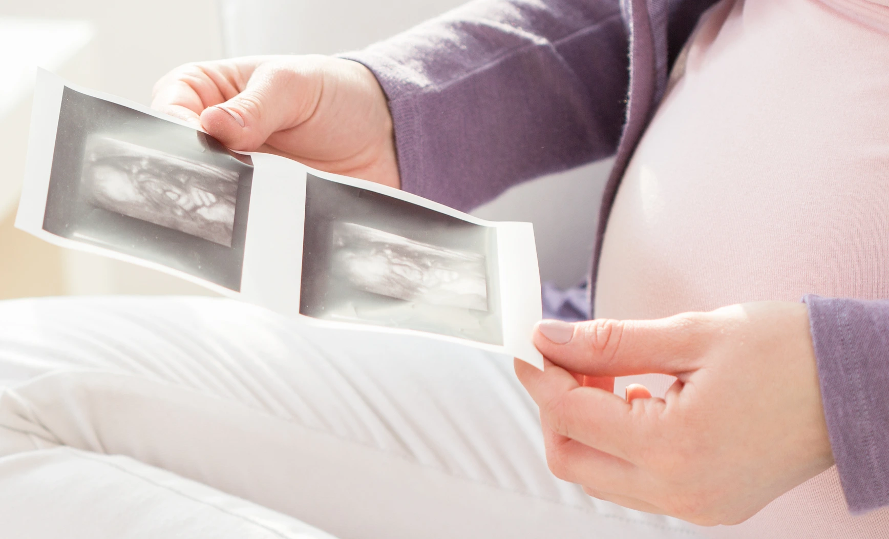 Schwangere Frau mit Ultraschallbildern