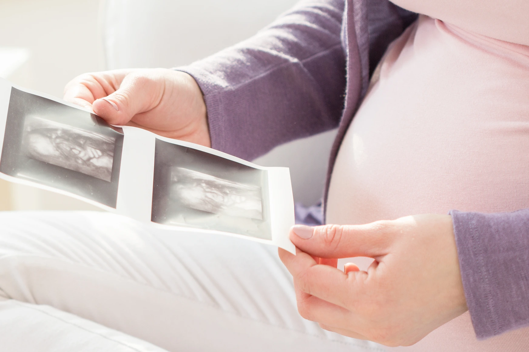 Schwangere Frau sieht sich Ultraschallbilder an
