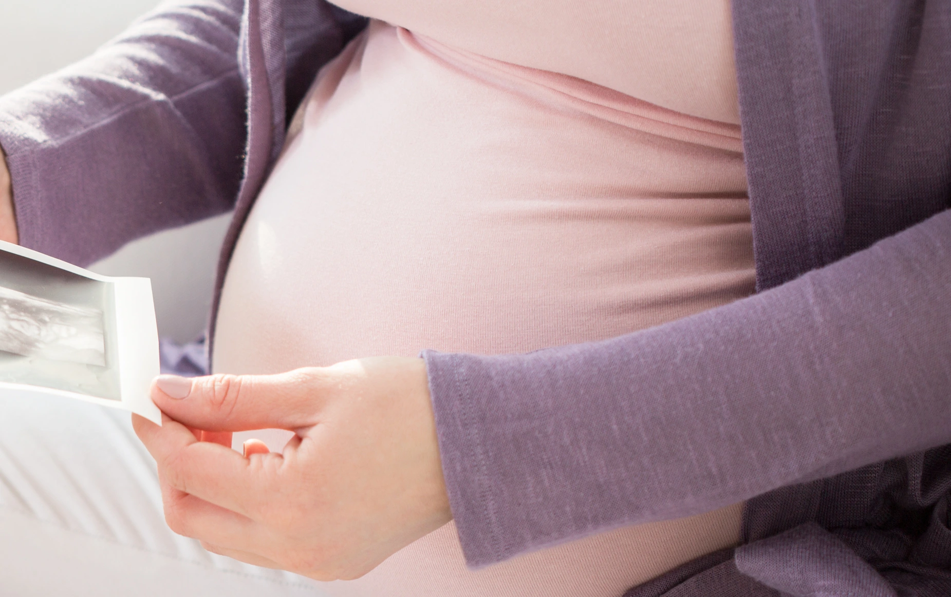 Schwangere Frau mit Ultraschallbildern