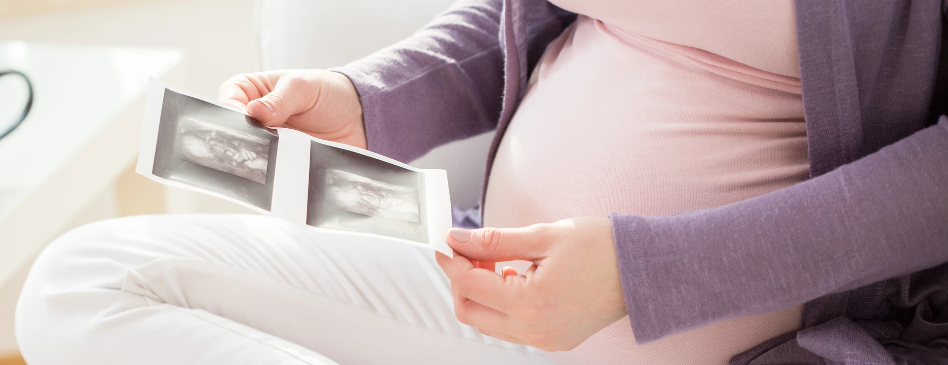 Schwangere Frau mit Ultraschallbildern
