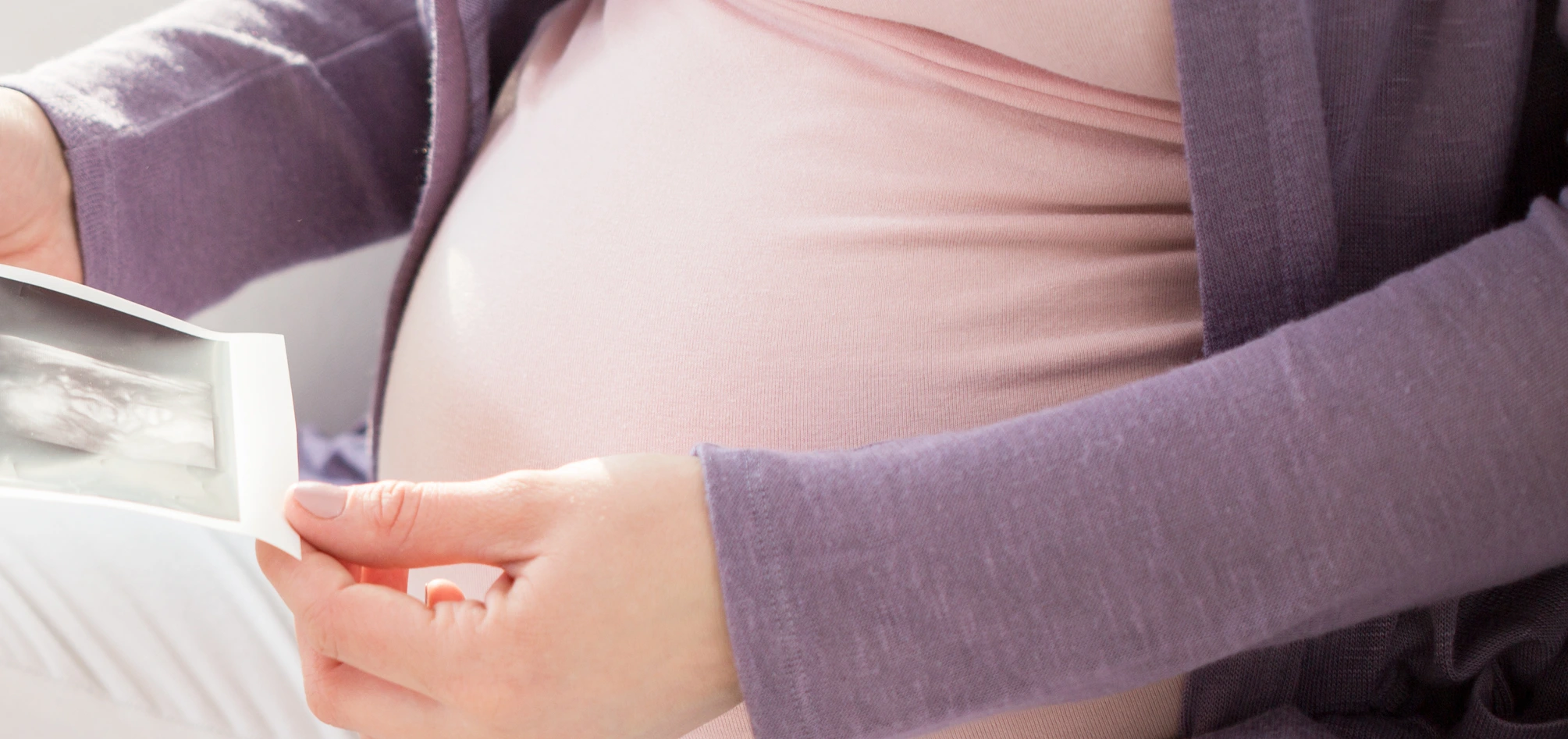 Schwangere Frau mit Ultraschallbildern