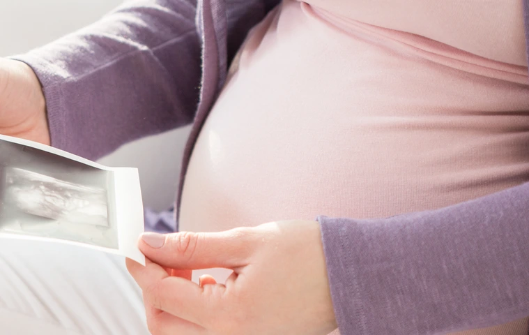 Schwangere Frau mit Ultraschallbildern