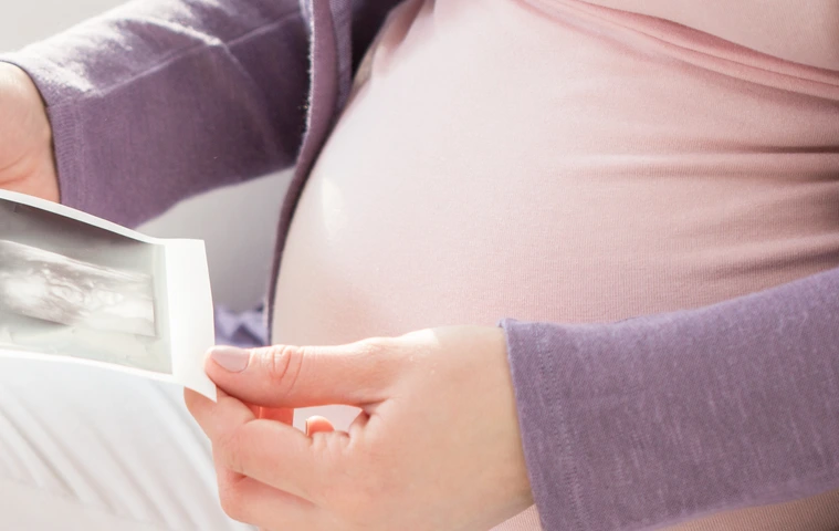 Schwangere Frau mit Ultraschallbildern