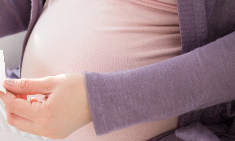 Schwangere Frau mit Ultraschallbildern