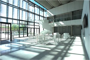 Spacious lobby with reception desk, seating areas, and open architectural design for conference center visitors.