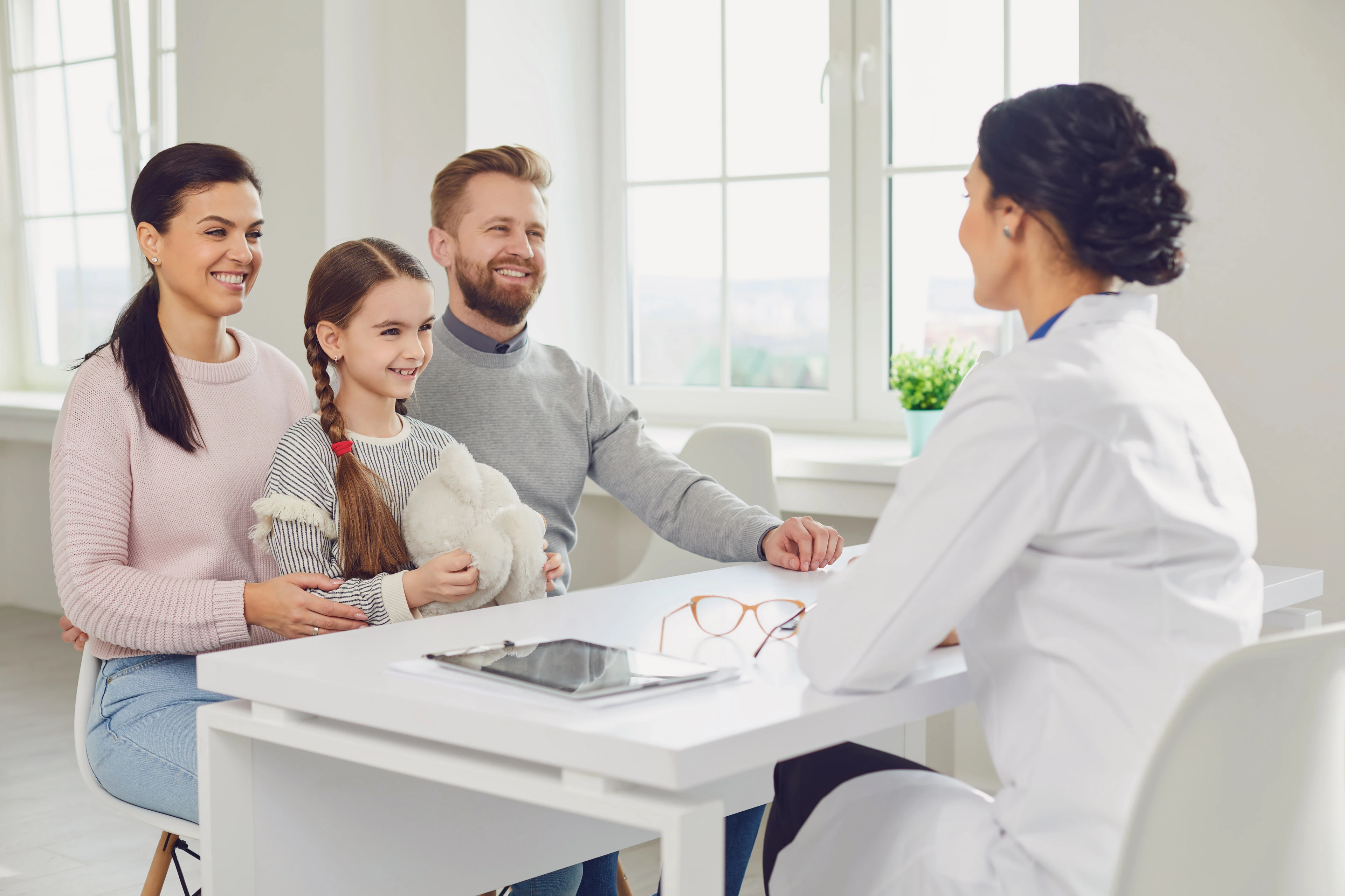 Happy family on a visit to the doctor in the office of a doctor.