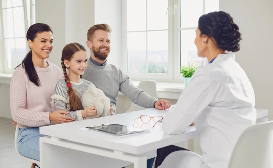 Happy family on a visit to the doctor in the office of a doctor.