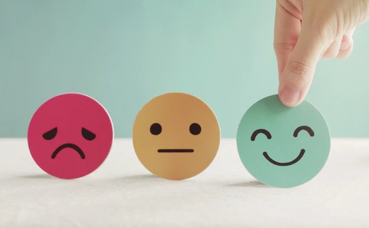 Hand choosing green happy smiley face paper cut
