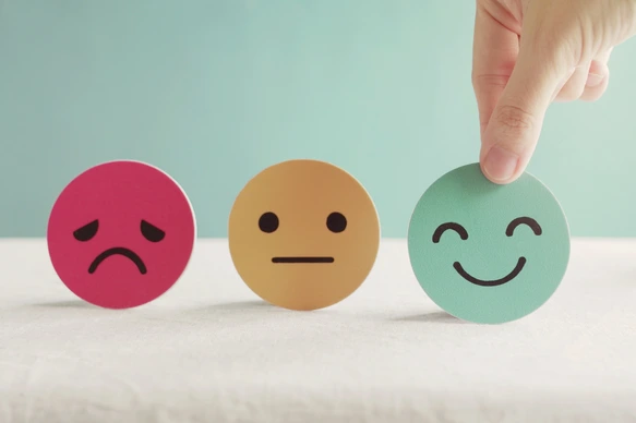 Hand choosing green happy smiley face paper cut