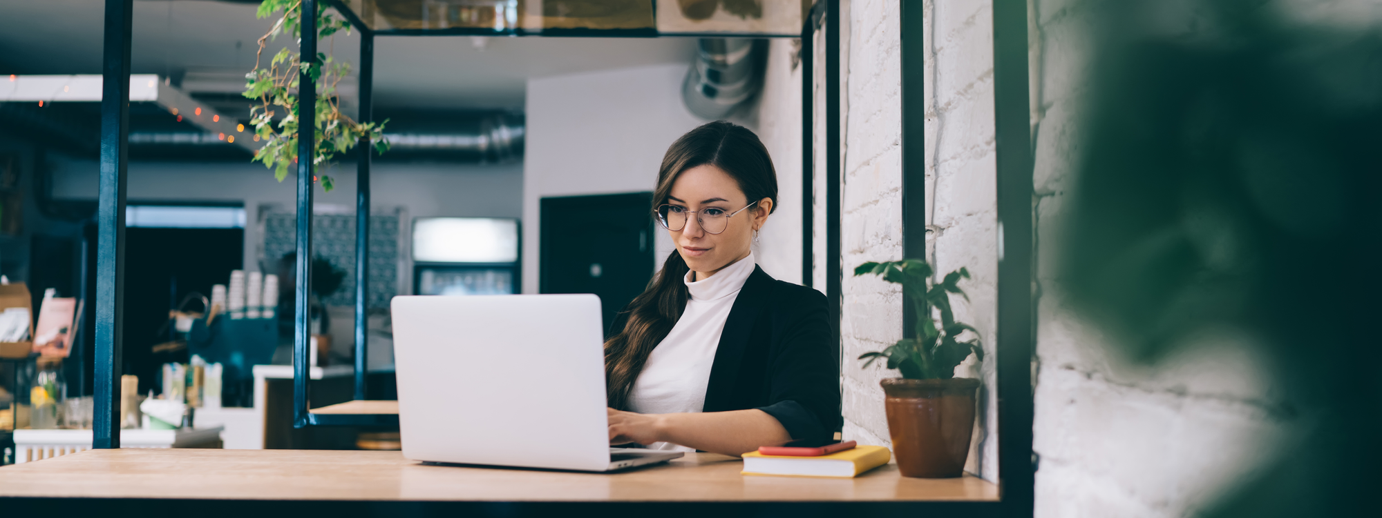 Young woman using laptop in loft cafe