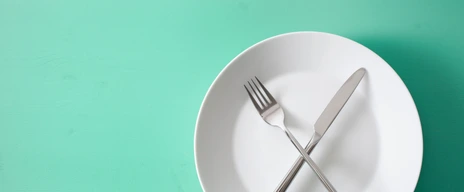 concept of intermittent fasting and ketogenic diet, weight loss. fork and knife crossed on a plate