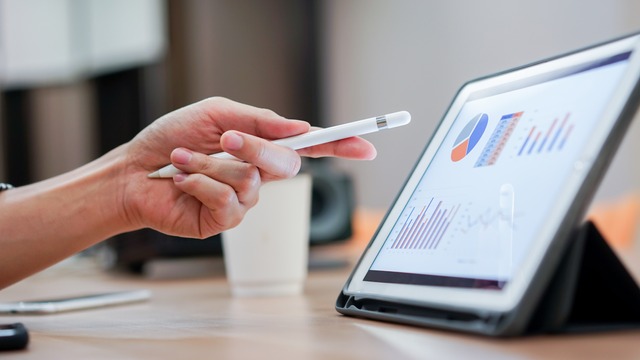 hand pointing at data on ipad