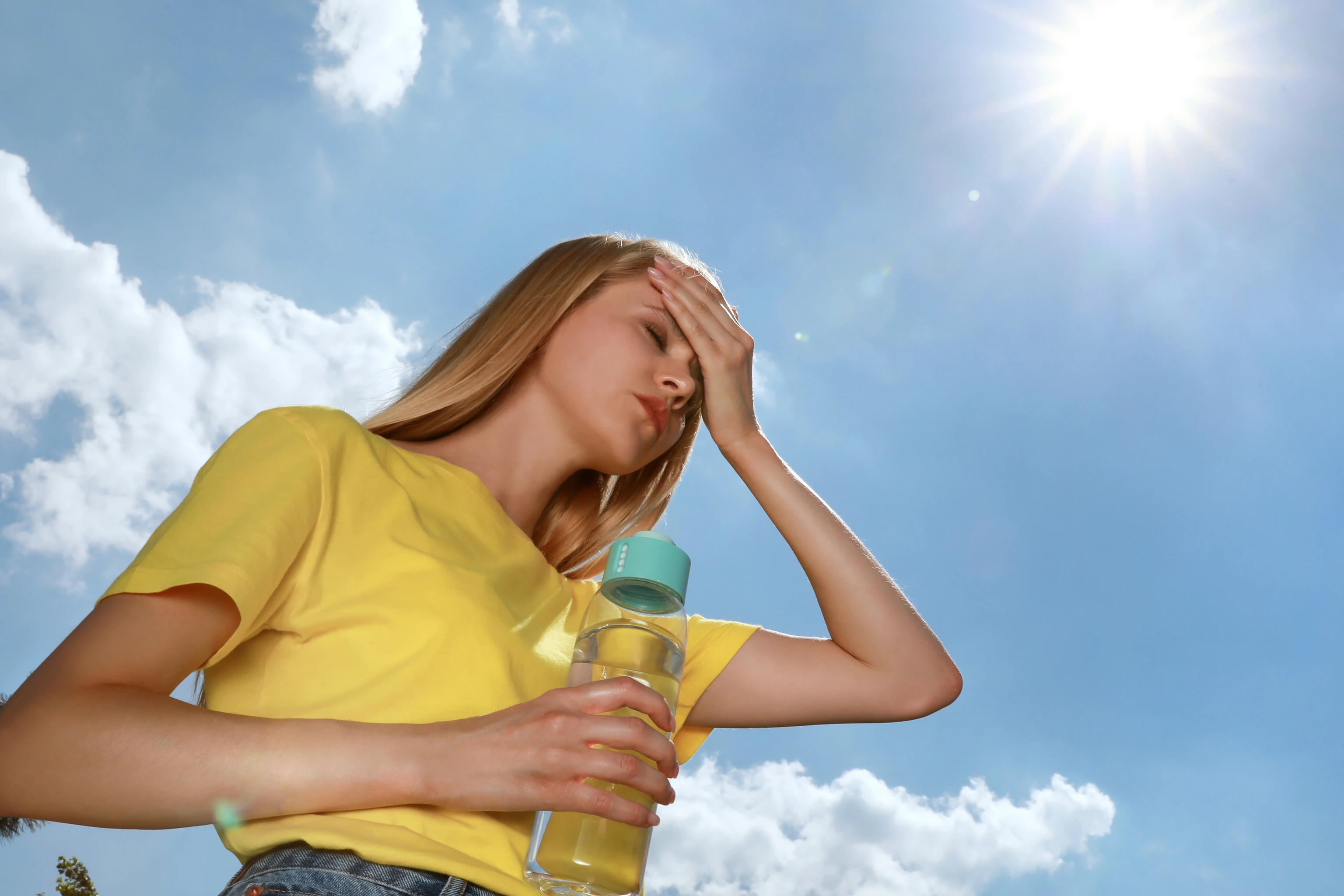 Woman with bottle of water suffering from heat stroke outdoors_Adobe Stock Bild_Für Lancet Countdown News 2024