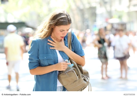 Asthmatic girl suffering an attack and searching inhaler