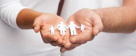 Hände halten Figuren aus Papier, die eine Familie darstellen - Vorbeugend vor Allergie schützen