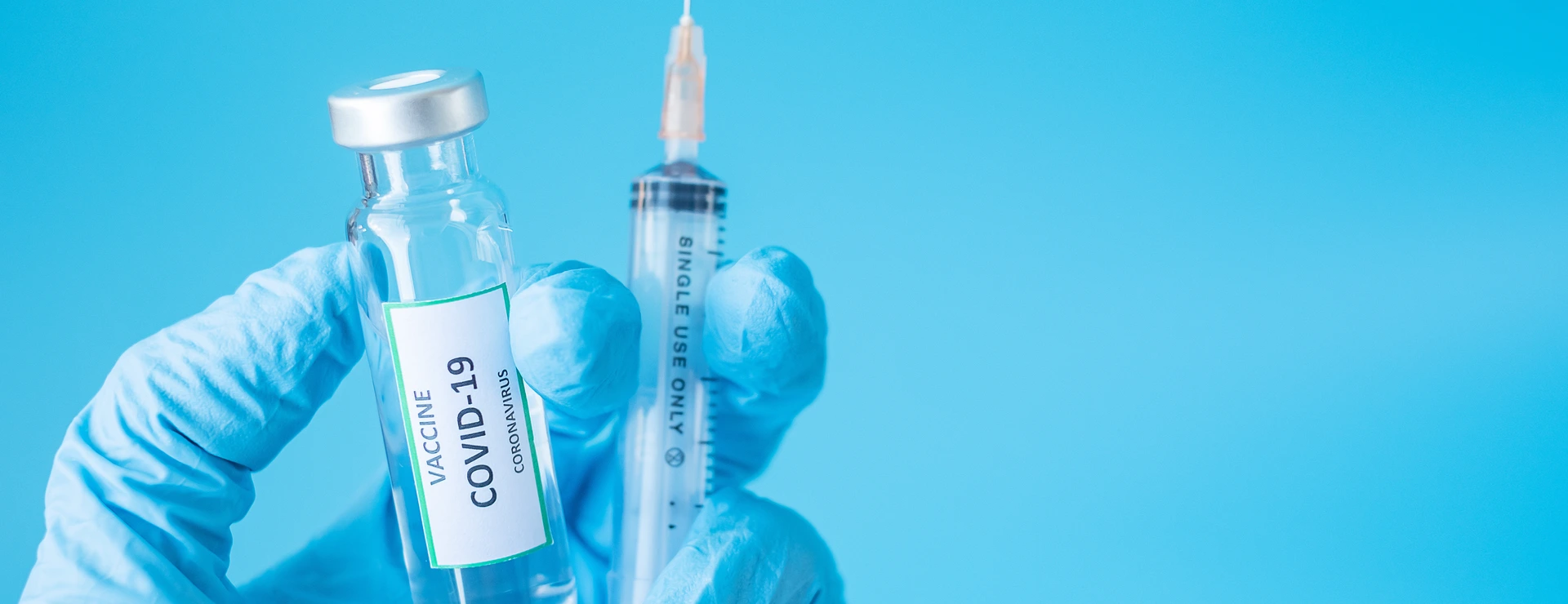 COVID-19 Vaccine vial and injection Needle Syringe against Coronavirus infection in hand of doctor with Nitrile Glove in hospital laboratory. Medical, health, Vaccination and immunization concept