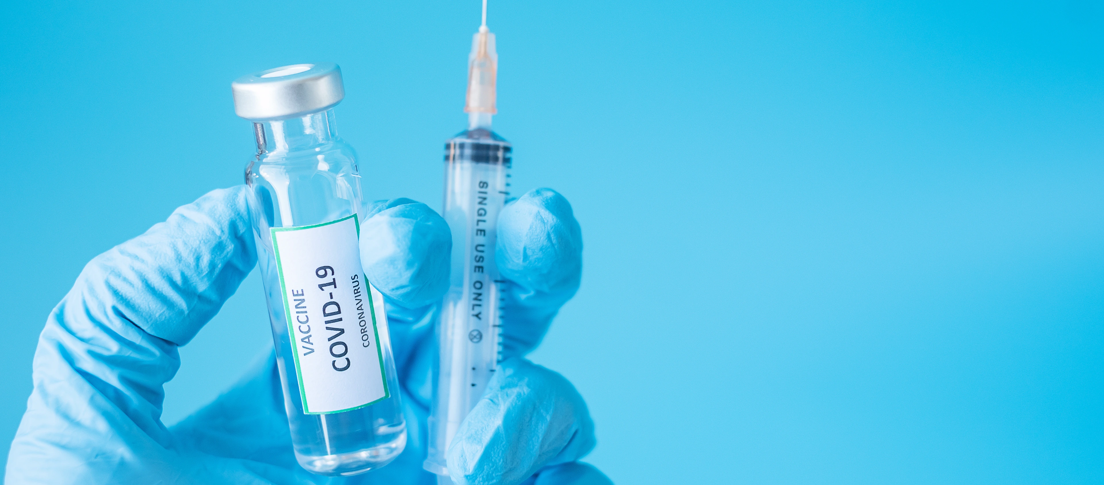 COVID-19 Vaccine vial and injection Needle Syringe against Coronavirus infection in hand of doctor with Nitrile Glove in hospital laboratory. Medical, health, Vaccination and immunization concept