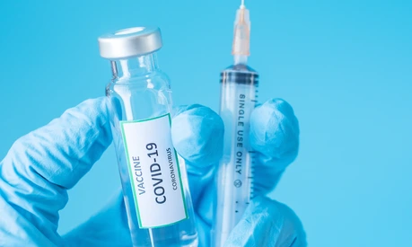 COVID-19 Vaccine vial and injection Needle Syringe against Coronavirus infection in hand of doctor with Nitrile Glove in hospital laboratory. Medical, health, Vaccination and immunization concept