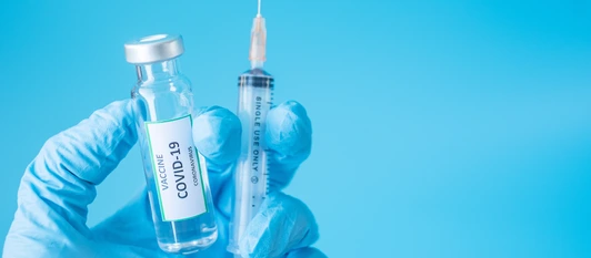 COVID-19 Vaccine vial and injection Needle Syringe against Coronavirus infection in hand of doctor with Nitrile Glove in hospital laboratory. Medical, health, Vaccination and immunization concept