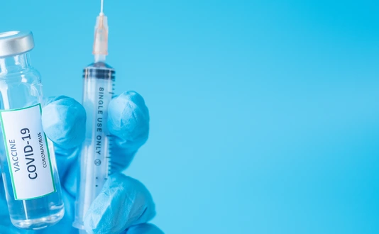 COVID-19 Vaccine vial and injection Needle Syringe against Coronavirus infection in hand of doctor with Nitrile Glove in hospital laboratory. Medical, health, Vaccination and immunization concept