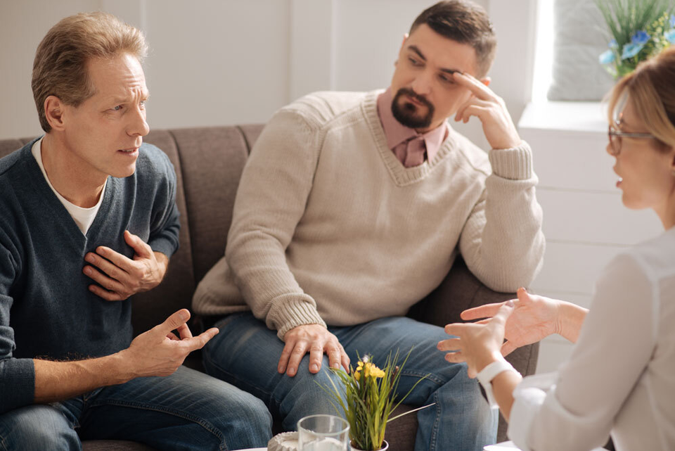 Ein homosexuelles Paar im Gespräch mit einem Paartherapeuten