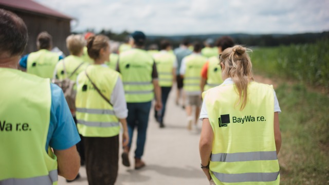 people in BayWa r.e. high is vests walking on a path